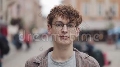 年轻的嬉皮士戴着眼镜站在城市街道上<strong>看</strong>镜头的肖像。 <strong>旅游</strong>、<strong>旅游</strong>